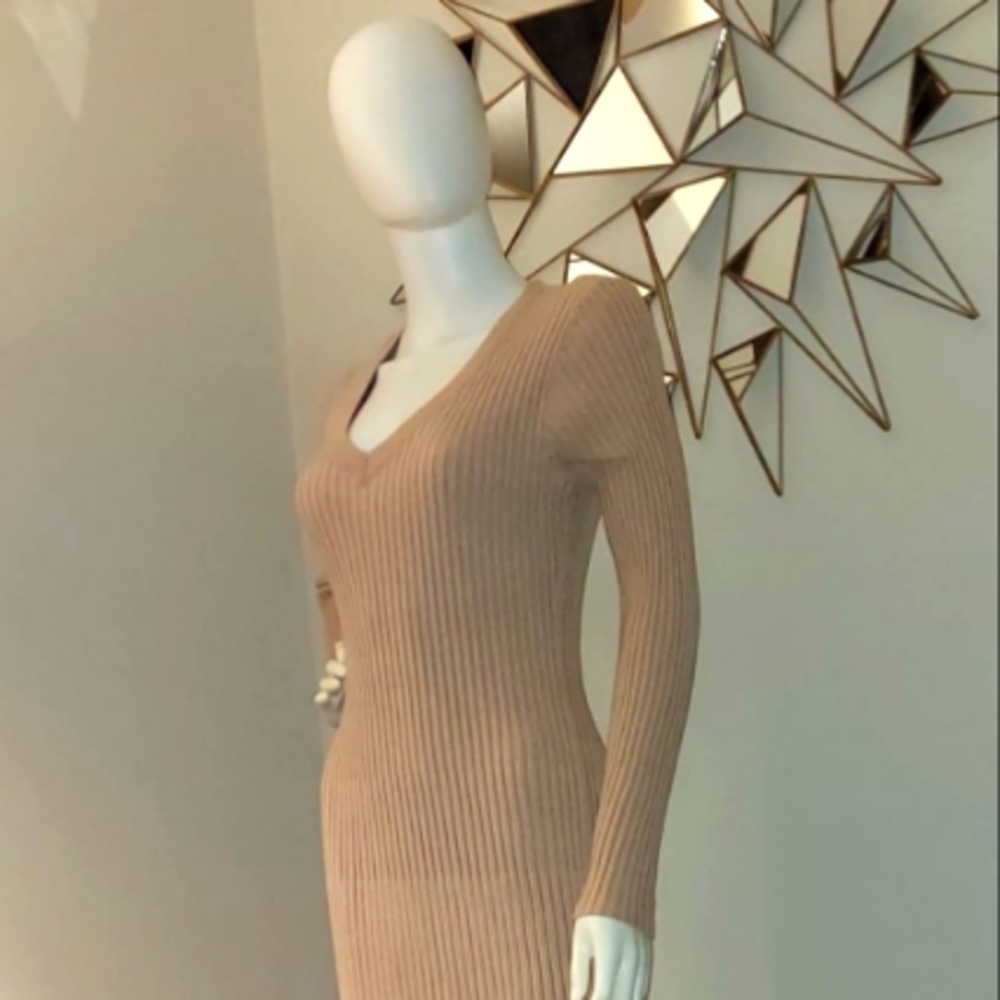 This stylish beige midi dress features a form-fitting ribbed knit